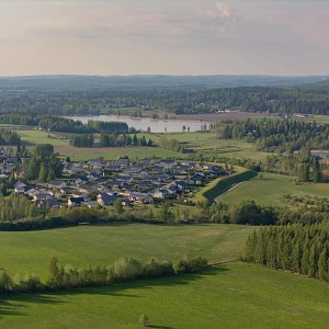 Näkymä pikkukaupungista keskellä vihreää peltoa.
