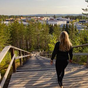 Nainen kävelee Kuilun kuntoportaissa Siilinjärvellä. Näkymä Siilinjärven keskustaan.