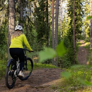 Henkilö maastopyöräilee pitkin Patakukkulan harjumaisemissa Siilinjärvellä.