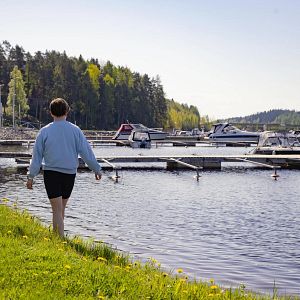 Nainen kävelee Vuorelan satamassa Siilinjärvellä laiturin vieressä.